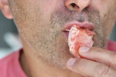 Bir erkek meyve yer.