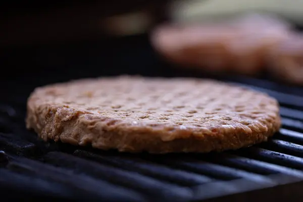 Hamburger patty placed on cast iron grill
