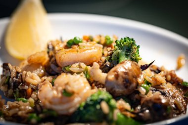 Beyaz tabakta sebzeli kızarmış karides.