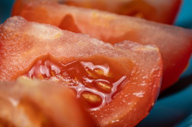 Kırmızı domatesler yakın bir tabakta domates parçalarına bölünmüş..