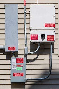 Fotovoltaik sistemin kullanımı hakkında uyarı etiketli elektrik kutuları