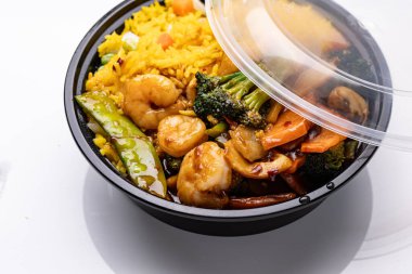 Çin pirinci, sebzeli ve karidesli beyaz arka planda siyah bir kutuda fotokopi alanı ile. Çin yemeği. Çin mutfağı..