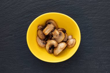 Arka planda siyah biberli bir kase kızarmış mantar. en üstteki görünüm