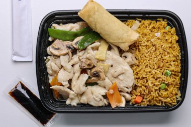 Plastik kabın içinde tavuk ve sebzeli Çin pilavı.