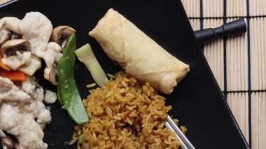 Plajda Asya yemeği. Yemekte soya sosu sıkan bir el..