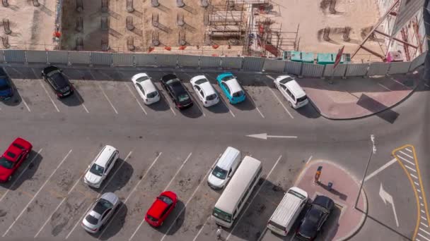 多くの車が出入りする駐車場のトップビュータイムラプス 近くの工事現場からの空中風景 — ストック動画