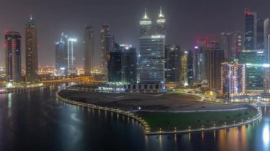 Dubai İş Koyu 'ndaki gökdelenlerin şehir manzarası. Bütün gece su kanalı havası var. Aydınlatılmış kuleleri ve rıhtımı olan modern gökyüzü. Uluslararası bir iş merkezi.