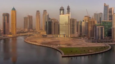 Gündoğumunda Dubai Business Bay 'in şehir manzarası gökdelenleri ve su kanalları zaman ayarlı. Kuleleri ve limanı olan modern gökyüzü. Uluslararası bir iş merkezi.