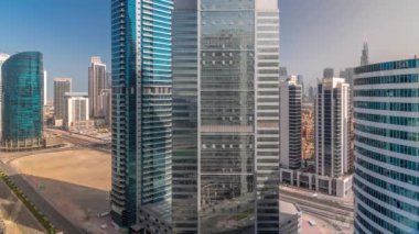 Dubai Business Bay 'in şehir merkezindeki gökdelenleri. Kuleleri ve gölgeleri hızlı hareket eden modern gökyüzü. Uluslararası bir iş merkezi.