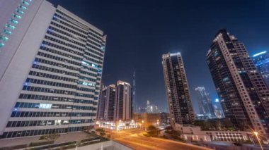 Şehir merkezindeki Dubai 'ye bakan hava panoramik manzarası ve tüm gece boyunca Business Bay bölgesindeki kavşakta yoğun trafik olan difc gökdelenleri..