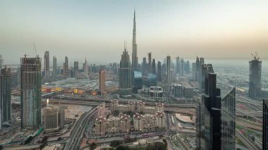 Dubai şehir merkezindeki en yüksek kulelerin havadan panoramik görüntüsü ve gündüz ve gece geçiş zamanı. Finansal bölge ve şehir merkezindeki iş alanı. Gökdelen ve gökdelen