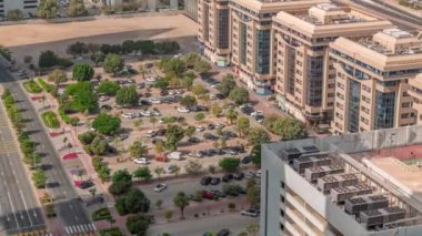 Otoparkta park halindeki sıra sıra yeşil yapraklı ağaçların arasına park etmiş. Yukarıdan zaman ayarlı görüntüler izliyorlar. Dubai 'deki yerleşim bölgesinin havadan görüntüsü