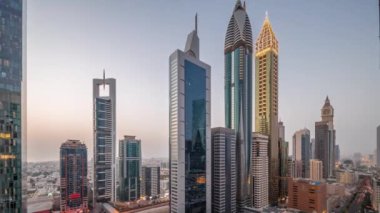 Günbatımından sonra Dubai Uluslararası Finans Bölgesi 'nin hava görüntüsü ve birçok gökdelen gece gündüz geçiş zamanı. Metro istasyonuyla çok katlı bir otoparkın yakınında trafik vardı. Dubai, BAE.
