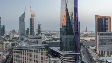 Günbatımından sonra Dubai Uluslararası Finans Bölgesi 'nin hava görüntüsü ve birçok gökdelen gece gündüz geçiş zamanı. Alışveriş caddesi ve ofis kulelerinin yakınındaki bir yolda trafik vardı. Dubai, BAE.