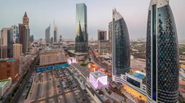 Dubai Uluslararası Finansal Bölgesi 'nin hava panoramik görüntüsü. Gün batımından sonra gece birçok gökdelen geçiş zamanı var. Alışveriş caddesi yürüme alanındaki otoparkın yanındaki yolda trafik vardı.