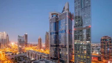 Dubai Uluslararası Finans Bölgesi 'nin hava görüntüsü. Günbegün geçiş zamanı birçok gökdelen var. Yanan kuleleri olan park yeri yakınındaki bir yolda trafik vardı. Dubai, BAE.