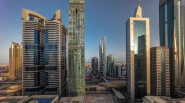 Dubai Uluslararası Finans Bölgesi 'nin hava gündoğumu görüntüsü ve birçok gökdelen zaman dilimi var. Sabahları uzun gölgeli çok katlı binaların yakınında trafik vardı. Dubai, BAE.
