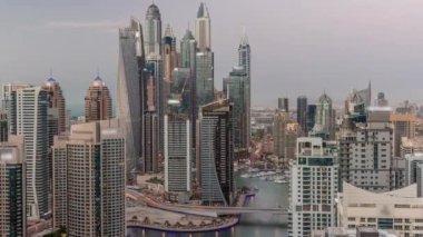 Dubai Marina hava sahasının en yüksek bloğundaki çeşitli gökdelenlerin görüntüsü suni kanalla gündüz gece geçiş zamanı. Gün batımından sonra birçok kule ve yat