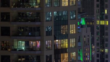 Parlak panoramik pencereli dış apartman binasının gece görüşü. Işıklı gökdelenle aydınlatılmış yüksek bir gökdelen