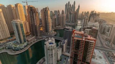 Sunrise Airial Timelapse sırasında Dubai Marina 'nın en yüksek karşılama bloğundaki çeşitli gökdelenlerin suni kanallı panoraması. Sabahın erken saatlerinde pek çok kule ve yat