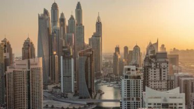 Sunrise Airial Timelapse sırasında Dubai Marina 'nın en yüksek karşılama bloğundaki yapay kanallı çeşitli gökdelenlerin görüntüsü. Turuncu gökyüzü ile sabahın erken saatlerinde pek çok kule ve yat