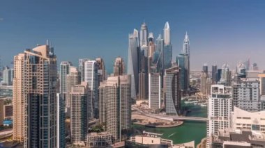 Gün batımında uzun gölgeli yapay kanallarla Dubai Marina 'nın en yüksek karşılama bloğundaki çeşitli gökdelenlerin görüntüsü. Pek çok kule ve yat