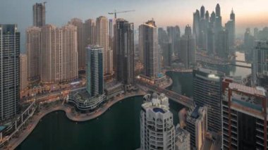 Dubai Marina ve JBR hava sahasındaki en yüksek bloktaki çeşitli gökdelenlerin görüntüsü gece gündüz yapay kanalla geçiş zamanı. Gün doğumunda çok sayıda kule ve yat