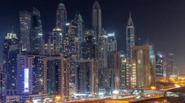 Dubai marinası tüm gece boyunca gökdelenlerin en yüksek binası ve ışıkları kapalı. JLT bölgesinden apartman binalarına, otellere ve otoyol yakınlarındaki iş kulelerine hava manzarası.
