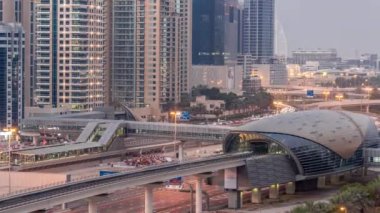 Dubai metro istasyonunun gelecekteki binası ve Dubai Marina hava sahasındaki lüks gökdelenler günden geceye geçiş zamanı. Şeyh Zayed karayolu, Birleşik Arap Emirlikleri 'nde trafik