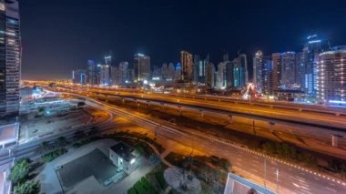 Dubai Marina Gökdelenleri 'nin panorama' sı ışıklar kapanıyor ve Şeyh Zayed yolu ile metro demiryolu antenli tüm gece boyunca. Modern kulelerin yakınındaki bir otoyolda trafik var, Birleşik Arap Emirlikleri