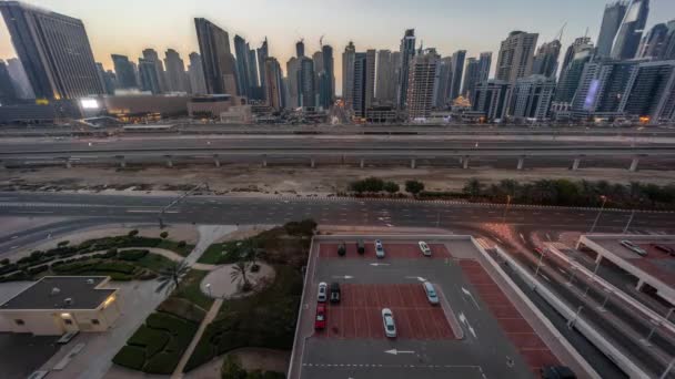迪拜的滨海摩天大楼和谢赫扎耶德公路 与地铁从空中到夜间的过渡时间过去了 在日落后俯瞰近现代塔楼的高速公路上的交通全景 — 图库视频影像