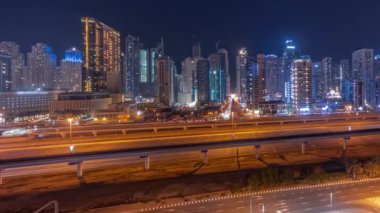 Dubai marinasının panorama 'sı tüm gece boyunca gökdelenlerin en yüksek binası ve ışıkları kapalı. JLT bölgesinden apartman binalarına, otellere ve otoyol yakınlarındaki iş kulelerine hava manzarası.