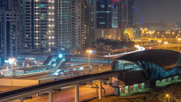 迪拜地铁站的未来派建筑和迪拜码头的豪华摩天大楼在夜间飞驰而过 阿拉伯联合酋长国谢赫扎耶德公路的交通情况 — 图库视频影像
