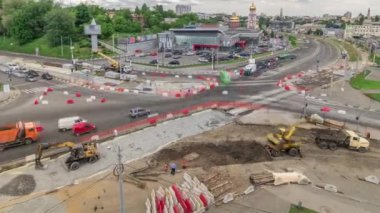 Büyük bir şehir kavşağının havadan görünüşü ile yol inşaatı alanındaki kentsel işler zaman ayarlı. Birçok endüstriyel ekipman vinç ve kazıcı ile tramvay raylarının yeniden inşasında. Kavşakta trafik vardı.