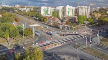 Şehir kavşağındaki asfaltlamanın hava görüntüsü yol inşaatı alanındaki kentsel çalışma zamanı. Tramvay raylarında birçok endüstriyel ekipman var. Kavşakta trafik vardı.