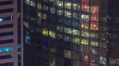 Gecenin ilerleyen saatlerinde gökdelenlerin camlarında parlayan ve yanıp sönen iç ışıkları olan pencereler. Havadan üst görünüm