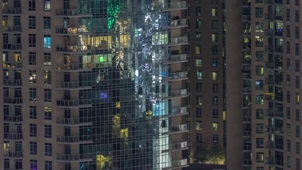 窓の光の列に輝く現代の住宅の建物の大きな輝く窓は夜にタイムラプスします — ストック動画