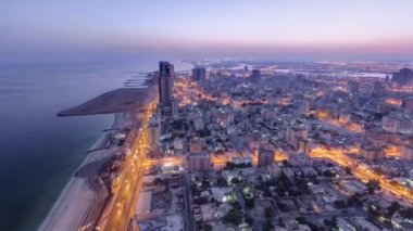 Ajman 'ın çatıdan şehire gece gündüz geçiş zamanı güneş doğmadan önce. Ajman, Birleşik Arap Emirlikleri 'nde Ajman Emirliğinin başkentidir..