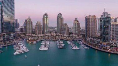 Dubai Marina gökdelenleri gün be gece geçiş zamanı panorama, lüks yatları ve marina gezinti alanı olan liman, Dubai, Birleşik Arap Emirlikleri. Aydınlatılmış kuleler ve yol trafiği
