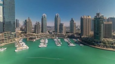 Dubai Yat Limanı gökdelenler aeral tüm gün timelapse günbatımı kadar bağlantı noktası ile lüks yatlar ve Yat Limanı sırasında gezi, Dubai, Birleşik Arap Emirlikleri. Gölge çok hızlı hareket ediyor. Mavi gökyüzü ve Zümrüt su