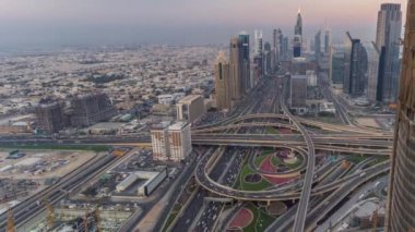 Dubai şehir merkezindeki ufuk çizgisi günden geceye geçiş zamanı. Şeyh Zayed kavşağındaki çok sayıda aydınlatma kulesiyle çatıdaki trafiğin görüntüsü.
