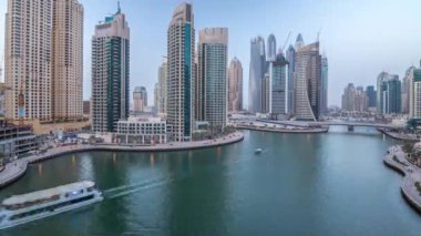 Dubai Marina gezinti güvertesi ve kanalı, gün batımından sonra Dubai, BAE 'de yüzen yat ve teknelerle hava görüntüsü. Modern kuleler ve trafik