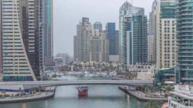 Dubai, BAE 'de gün batımından sonra yüzen yat ve teknelerle Dubai Marina gezinti güvertesi ve kanallarının havadan zamana güzel bir görüntüsü var. Modern kuleler ve yoldaki trafik.