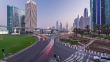 Kavşak ve köprü gece geçiş timelapse gökdelenler gün çevrili Sheikh Zayed Road üzerinde trafik. Yukarıdan akşam itibariyle Birleşik Arap Emirlikleri Dubai oteli göster