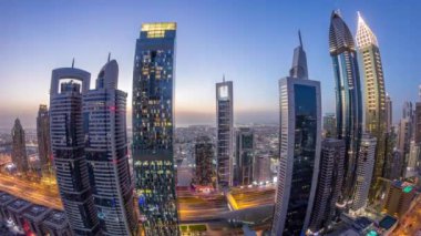 Sheikh Zayed Yolu 'nun gökyüzü manzarası ve Dubai, BAE' deki gece gündüz geçiş zamanı. Finans merkezindeki gökdelenler gün batımından sonra yukarıdan hava görüntüsü