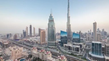 Dubai şehir merkezindeki Panorama 'dan gece, gündüz en yüksek binayla ve Şeyh Zayed karayolu trafiğiyle geçiş zamanı. Günbatımından sonra modern kulelerle gökdelenin çatısından gökyüzü manzarası