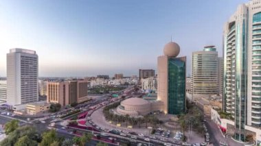 Dubai Creek alan modern binalar ve yoğun trafik sokak gün gece geçiş timelapse çevrili. Işıklandırılmış gökdelenler ile güneş battıktan sonra yukarıdan hava üstten görünüm