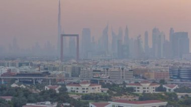 Dubai deresi manzarası günden geceye geçiş zamanı aydınlatılmış modern binalar ve şehir merkezindeki gökdelenler ve gökdelenler. Yukarıdan hava üstü görünümü