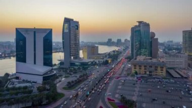 Dubai creek peyzaj gün gece geçiş timelapse tekneler ve yatlar ile ve trafik yol ve otopark ile modern binalar. Yukarıdan hava üstten görünüm