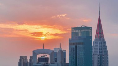 Dubai 'nin finans merkezi üzerinde gün batımı lüks gökdelenler zaman çizelgesi, Dubai, Birleşik Arap Emirlikleri. Turuncu gökyüzü ve kuleleri olan çatılar.